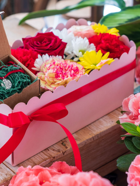 composizione in spugna di fiori freschi e gioiello in argento in scatola rosa con coperchio trasparente