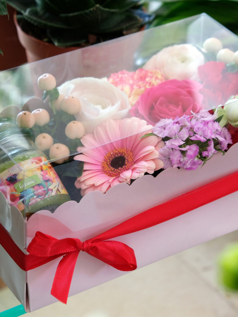 composizione in spugna di fiori freschi e candela in scatola rosa con coperchio trasparente