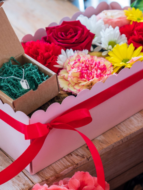 composizione in spugna di fiori freschi e gioiello in argento in scatola rosa con coperchio trasparente
